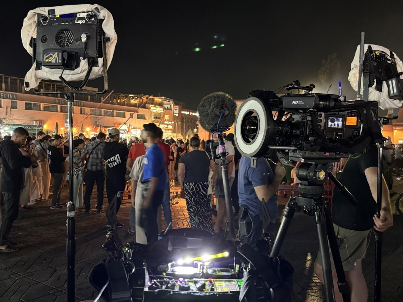 Camera and lighting crew filming at night in a Marrakech square